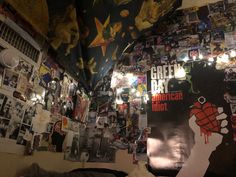 a room filled with lots of posters and pictures on the wall next to a bed