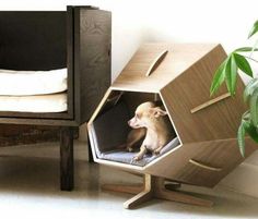 a small dog sitting in a wooden structure next to a plant and bed with white sheets