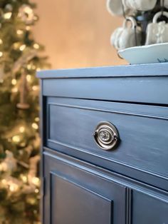 a blue dresser in front of a christmas tree