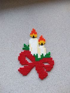 a cross stitch ornament with two chickens sitting on it's own legs