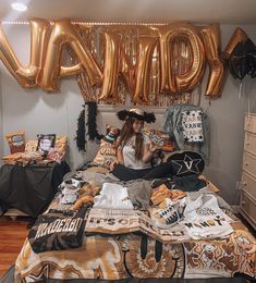 a woman sitting on top of a bed in a room with balloons and decorations around her