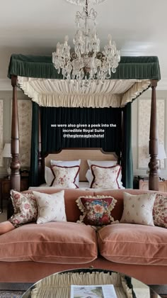 a canopy bed sitting in the middle of a living room next to a chandelier