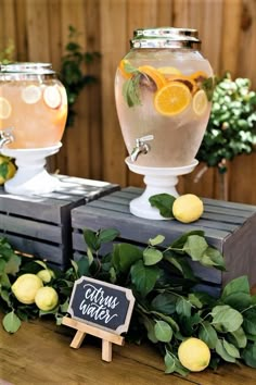 there are lemons and water in the vases on the table with chalkboard signs