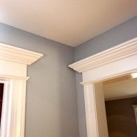 a bathroom with blue walls and white trim on the wall, along with two mirrors