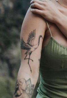 a woman with a bird tattoo on her arm