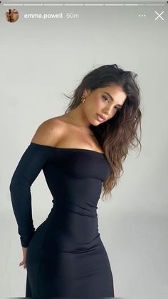 a woman in a black dress posing for the camera with her hands on her hips