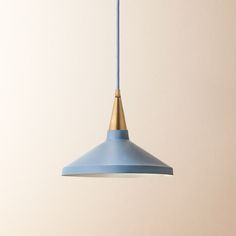 a blue and gold colored light hanging from a ceiling in a room with beige walls