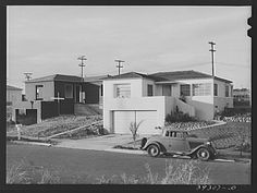 an old car parked in front of some houses