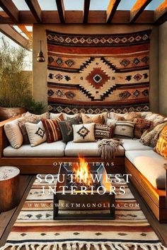 an outdoor living room with a fire pit and rugs on the wall above it