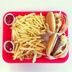 a red tray topped with two hot dogs and fries