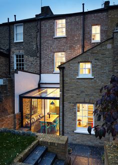 an outside view of a brick building with windows on the side and patio in front