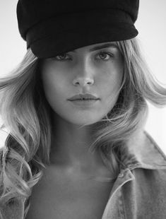 a black and white photo of a woman wearing a hat