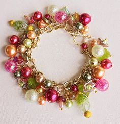 Make a statement with this one-of-a-kind floral charm bracelet. Gold wire wrapped freshwater pearls, glass pearls, cut Swarovski crystals, Czech glass flowers and leaves, gold plated findings, and assorted glass beads are hung on a gold-plated chain and finished with a matching toggle clasp.  This bright and colorful beaded bracelet comes with all charms shown. Bracelet length can be adjusted as requested, prior to checkout, by selecting a size. Makes a great addition to your collection or a wonderful gift for someone special. Multicolor Flower-shaped Jewelry With Charms, Whimsical Colorful Beaded Bracelet, Flower Charm Bracelet, Charm Bracelet Gold, Wedding Charm, Bracelet Flower, Bracelet Wedding, Swarovski Crystal Bracelet, Orange And Green