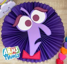 a purple paper plate with an angry face on it next to some candy candies