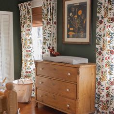 a baby crib in the corner of a room next to a window with curtains