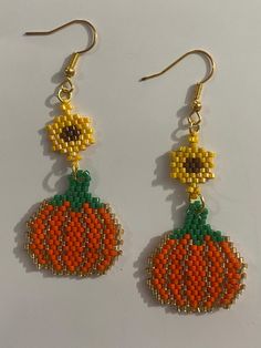 the beaded pumpkin earrings are orange and green