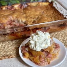 a piece of pie on a plate next to a casserole dish with whipped cream