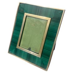 a green and gold photo frame on a white background with an empty square in the middle