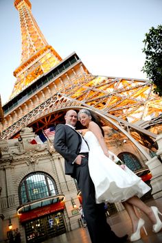 a bride and groom pose in front of the eiffel tower at their wedding