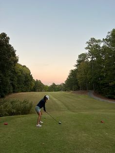 a woman is playing golf on the green