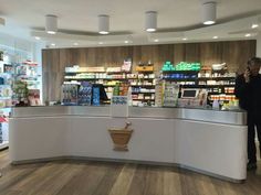 a man is talking on his cell phone at the counter in a store with shelves full of products