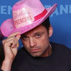 a man wearing a pink cowboy hat with the words birthday princess on it's brim