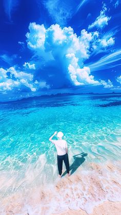 a man standing in the ocean with his hat on