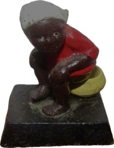 a small figurine of a baby sitting on top of a ball and wearing a red shirt