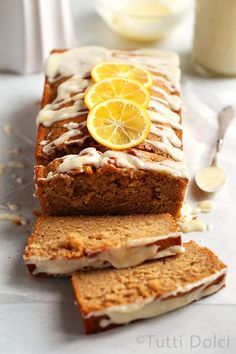 sliced loaf of lemon bread with icing and orange slices