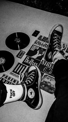 black and white photograph of someone's feet with various stickers on the floor