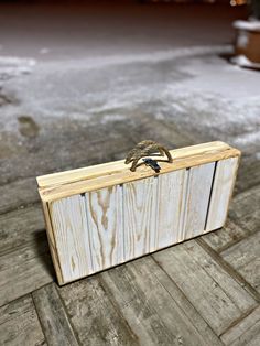 a wooden box sitting on top of a floor next to a building with snow covered ground