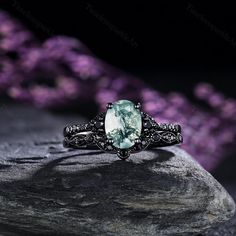 an oval cut aqua blue topazte ring with filigrees and black diamonds