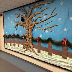 a decorated bulletin board with a tree and snowflakes on the wall in front of it