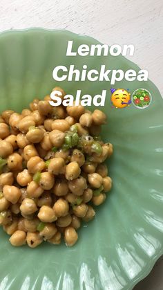 a green bowl filled with chickpea salad on top of a table