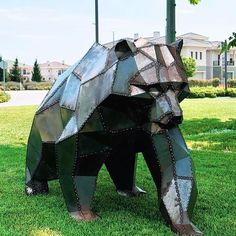 a sculpture of a bear in the grass