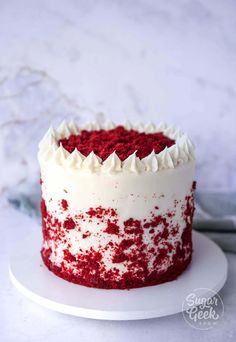 a red velvet cake with white frosting and sprinkles on a plate