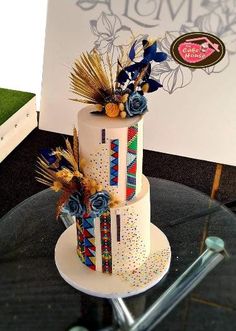 a multi - tiered cake decorated with flowers and feathers