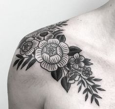 a black and white photo of a man's shoulder with flowers on it,