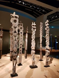 several wooden sculptures are on display in a museum