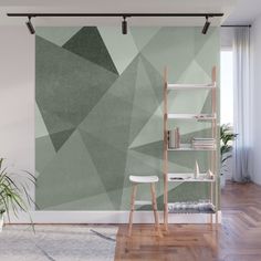 a room with a green wall and wooden flooring that has an abstract design on it