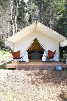 two chairs are sitting in front of a tent