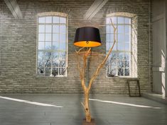 a lamp that is on top of a wooden stand in front of a brick wall