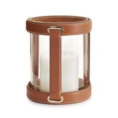 a candle holder with a leather strap around the top and bottom, on a white background