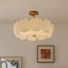 a chandelier hanging from the ceiling in a room with pictures on the wall