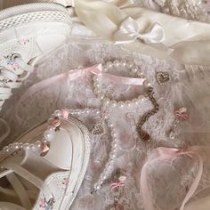 white shoes and pearls are laying on the lace covered bed sheet, next to a pair of slippers