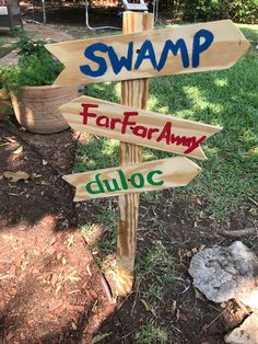 a wooden sign with several different signs on it's side in front of a tree