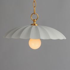 a white light hanging from a ceiling fixture with a gold chain around it and an oval glass shade on the bottom