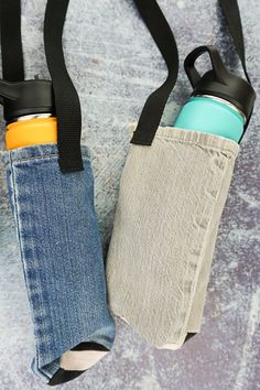 two water bottles are in the back pocket of a bag with straps hanging from it