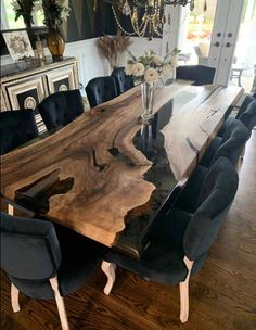 a dining room table with black chairs around it