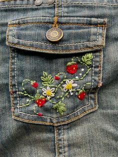 the back pocket of a pair of jeans with embroidered flowers